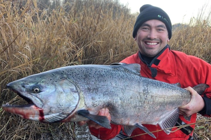 a young boy holding a fish