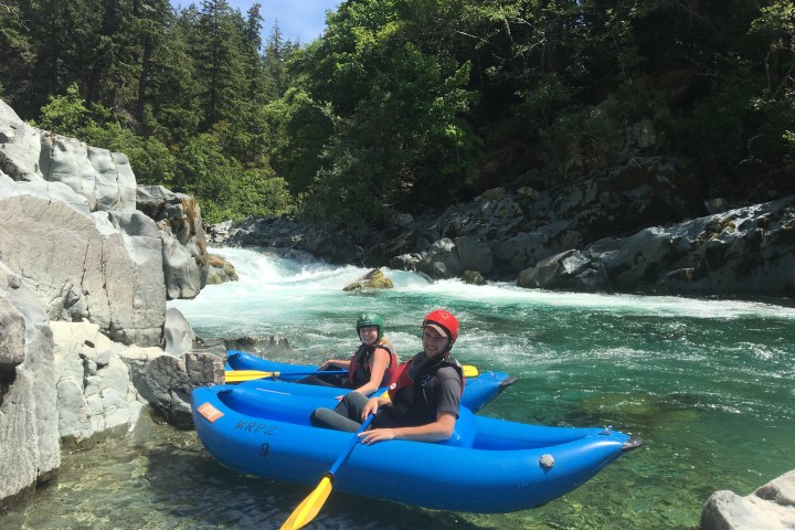 Two single kayakers floating in calm section of river