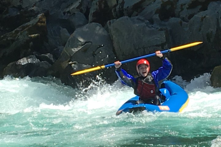 man kayaking down white water river